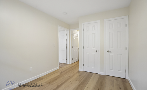 A room with white doors and wooden floors.